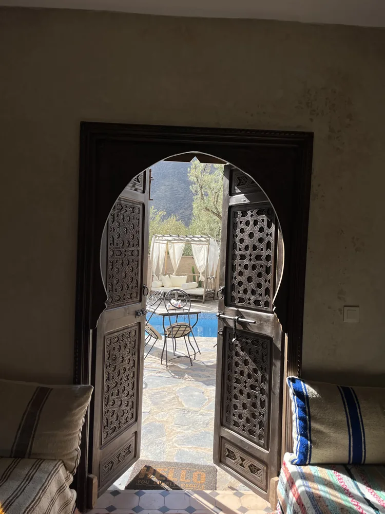 Porte en arabesque encadrant la piscine — architecture traditionnelle marocaine, Wild Valley Ouirgane